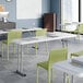 An 18-inch by 72-inch granite white heavy-duty blow-molded plastic folding table with gray legs, set up in a classroom setting.