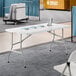 A rectangular granite white plastic bi-folding table with gray metal legs.