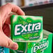 A hand holding a Wrigley's EXTRA Spearmint Gum 10-pack.