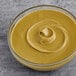 A pail of Vor Pistachio cream on a gray surface.