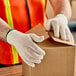 A person wearing Lavex work gloves opening a box.