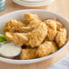 A bowl of Blackbird Foods plant-based breaded wings with dipping sauce and celery.