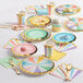 A table set with pastel napkins, plates, and cups.