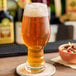 A glass of Hopzoil MAJIK® Saaz hop extract in a glass of beer on a table.