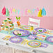 A table set with Creative Converting Modern Easter paper luncheon napkins, plates, and cups with easter decorations.