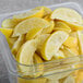 A clear container of Dole Chef-Ready Cuts IQF lemon wedges.