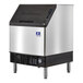 A silver and black Manitowoc undercounter ice cube maker.