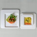 Two Jungle Diamond square plates of food on a table.