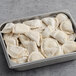 A metal tray filled with Jaju Butternut Squash, Apple, and Sage Pierogies.