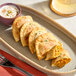 A plate of Jaju Butternut Squash, Apple, and Sage Pierogies with dipping sauce.