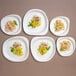 A stack of Jungle Stone compostable sugarcane pulp plates with pasta and shrimp on one plate.