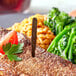A steak with Royal Paper brown medium well steak marker and vegetables on a plate.