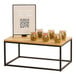 A black metal rectangular display riser with glass jars of food on it.