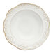 A white stoneware soup bowl with a scalloped edge and embossed floral design.