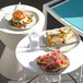 A set of ivory coupe melamine pasta bowls, each holding 30 oz, displayed with various sandwiches and toasts.