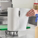 A hand holding a Scott Choose-a-Sheet paper towel roll.