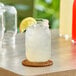 A glass jar of Sunkist Lemonade with a drink in it on a table.