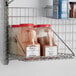 Metro PBA-MS SmartWall G3 Chrome Square Grid Shelf with jars of spices on it.