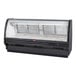 A Howard McCray black refrigerated curved glass meat case on a counter.