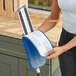A woman holding a blue and white Lavex microfiber mop pad.