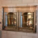 A Wood Stone liquid propane countertop vertical rotisserie oven with 6 spits over a fire.