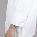 A man wearing a white Chef Revival long sleeve chef jacket with Chef logo buttons.