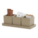 A taupe rectangular resin tray with three compartments holding condiments.