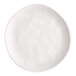 A white round melamine plate with a slightly irregular edge.