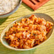 A bowl of chopped, fermented kimchi with a reddish hue, served as a side dish.