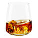 A Tossware plastic rocks glass filled with amber liquid and ice cubes.