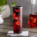 A glass of DaVinci Gourmet blackberry syrup with ice and berries in it.