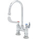 A T&S chrome deck-mounted faucet with 4" wrist action handles and a 5 1/2" rigid gooseneck spout.