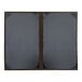 Two brown H. Risch, Inc. customizable menu covers with black album style corners on a wooden table.