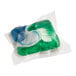 A single Cascade Complete ActionPac dishwasher detergent pod with green, blue, and white sections in a clear dissolvable wrapper.