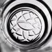 A clear glass with a dahlia-inspired geometric pattern on the bottom, designed for serving 8 oz. of beverages.