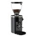 A black on-demand espresso grinder with a clear hopper containing coffee beans.