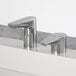A close-up of a Bobrick polished chrome deck-mount automatic liquid soap dispenser.