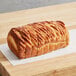 A loaf of Bridor pure butter flaky bread placed on a sheet of parchment paper on a wooden surface.