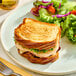 A sandwich made with sliced pure butter flaky bread loaf, served with a side salad.