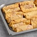 A tray of frozen raspberry cheesecake dessert log egg rolls.