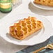 A rectangular apple pie Danish pastry with a honeycomb-patterned top, served on a white plate.