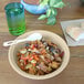 A World Centric compostable take-out bowl filled with pasta and vegetables on a table.
