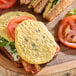 A fully cooked jalapeno scrambled egg patty served on a sandwich with tomato, bacon, greens, and bread.