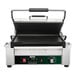 A Waring Tostato Supremo Panini Grill with a black and green handle.