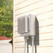 The white Bromic Heating dimmer controller box with wires attached to a wall.
