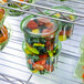 A group of green Eco-Products plastic deli containers filled with fruit.