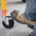 A 5-inch swivel caster with a locking pin being engaged by a person wearing a work boot.