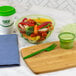 A bowl of vegetables and a wooden cutting board with a green Eco-Products Cutlerease fork.