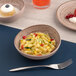 A dessert in an Ariane Tornado sage coupe bowl with a spoon.