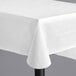 A white solid vinyl table cover with a flannel back, shown draped over a rectangular table.